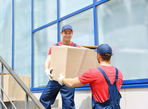 Trained movers handling boxes carefully during a removal